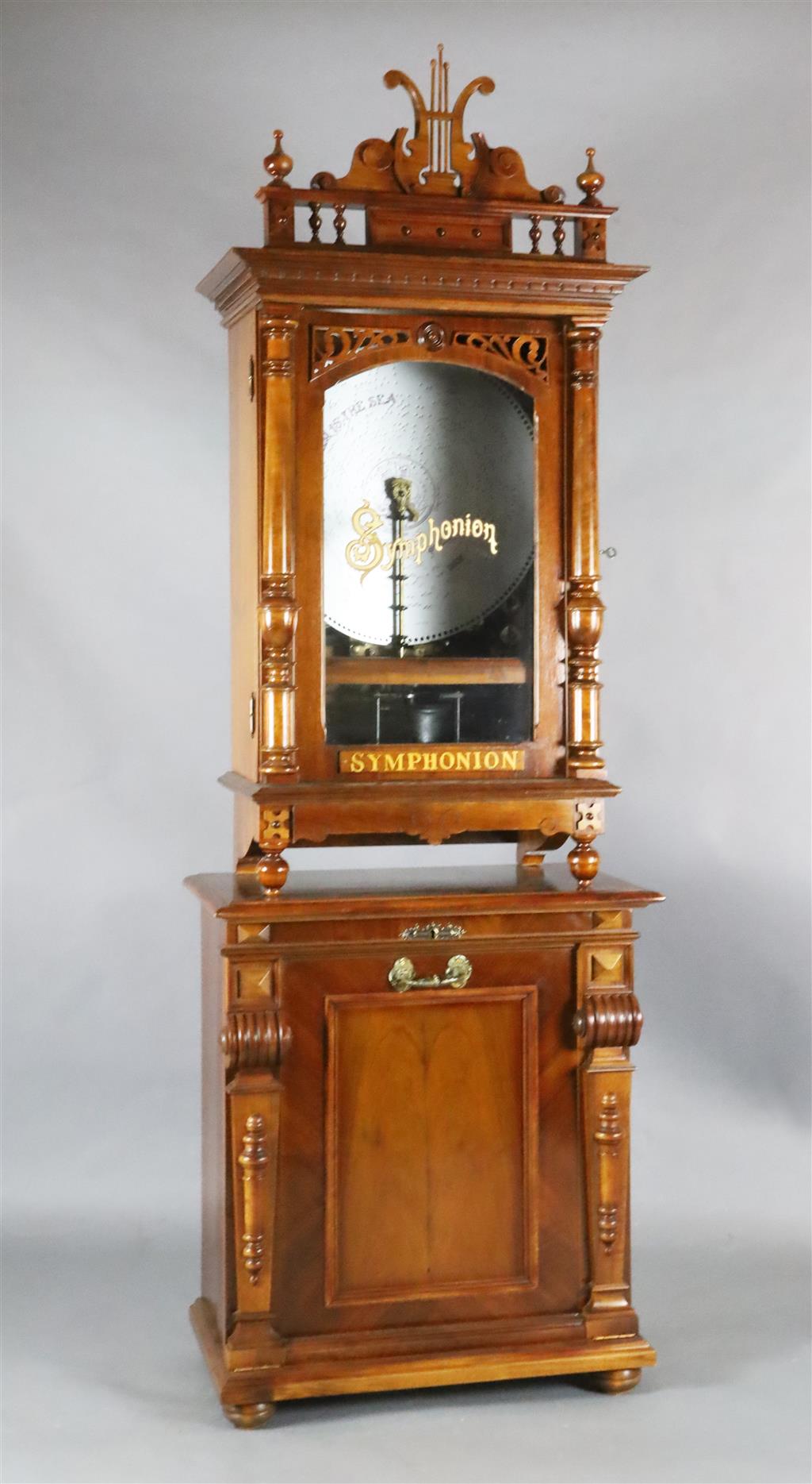 A late 19th century German walnut cased upright Symphonion, W.2ft 6in. D.1ft 4in. H.7ft 5in.